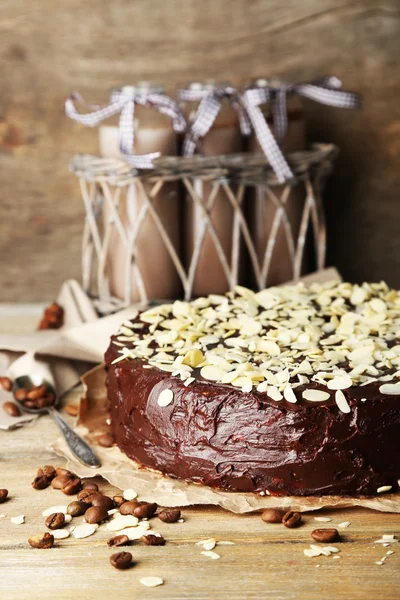 Leckere Schokoladenkuchen mit Mandeln, auf Holztisch, auf dunklem Hintergrund — Stockfoto