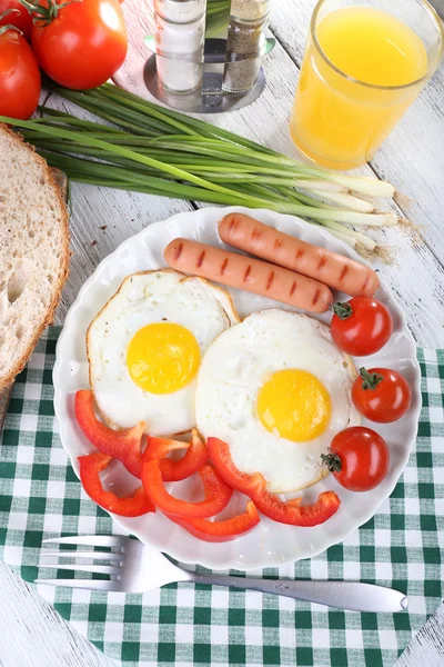 Äggröra med korv och grönsaker serveras på tallrik på servett — Stockfoto