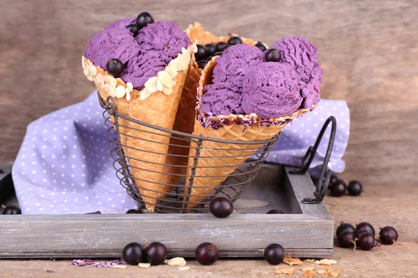 Sorvete saboroso com bagas em cones de waffle no fundo de madeira marrom — Fotografia de Stock