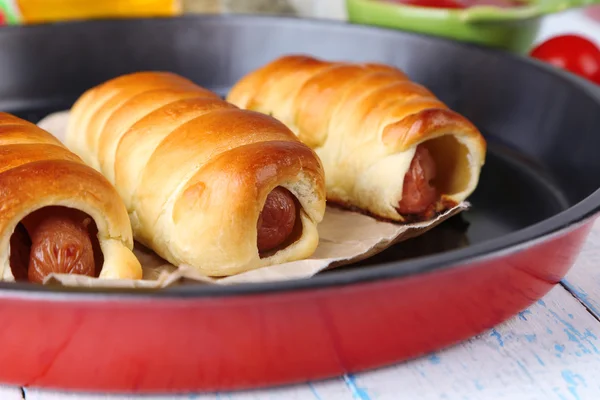 Baked sausage rolls in pan on table close-up — Stock Photo, Image