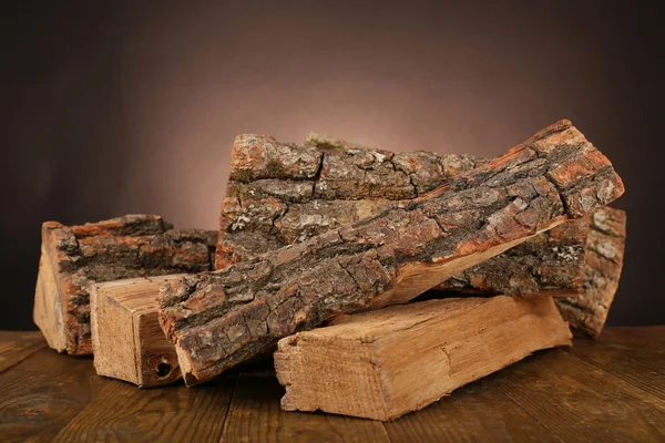 Heap of firewood on floor on dark background — Stock Photo, Image
