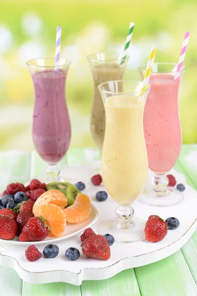 Köstliche Beerencocktails auf dem Tisch vor hellem Hintergrund — Stockfoto