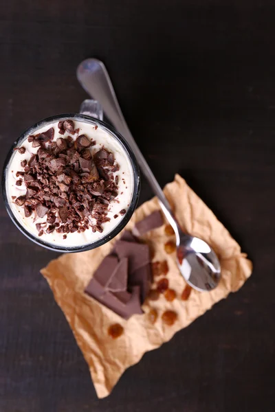 Yogourt, à la crème au chocolat, chocolat haché et muesli servi en verre sur fond de bois — Photo