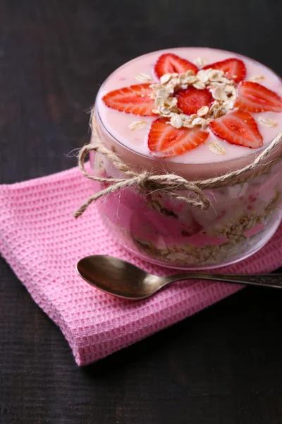 Colazione sana - yogurt con fragole e muesli servito in barattolo di vetro, su sfondo di legno — Foto Stock