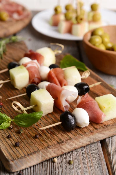 Delicious melon with prosciutto on table close-up — Stock Photo, Image