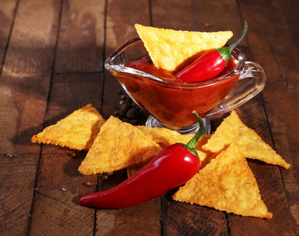 Tasty nachos and bowl with sauce on wooden background — Stock Photo, Image