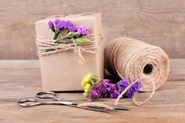 güzel hediye çiçek ve eski ahşap zemin üzerinde dekoratif ip ile