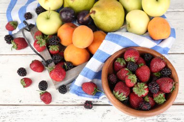 Olgunlaşmış meyve ve çilek kase masa üzerinde kapat