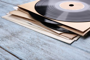 vinil kayıtları ve kağıt kapakları ahşap zemin üzerinde