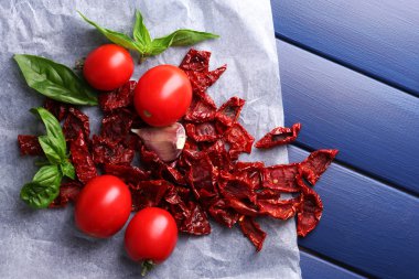 kurutulmuş ve taze domates, fesleğen yaprağı, sarımsak renk ahşap zemin üzerinde