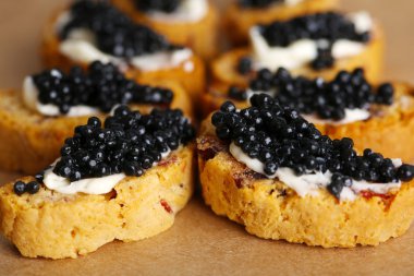 Kağıt arka plan üzerinde siyah havyar ve tereyağı ile ekmek dilimleri