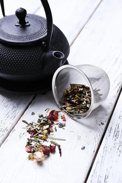 Black teapot, bowl and tea on color wooden background — Stock Photo, Image