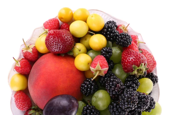 Different berries and fruits in plate isolated on white — Stock Photo, Image