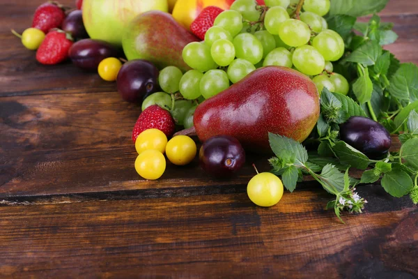 Different berries and fruits on wooden table close-up — Stock Photo, Image