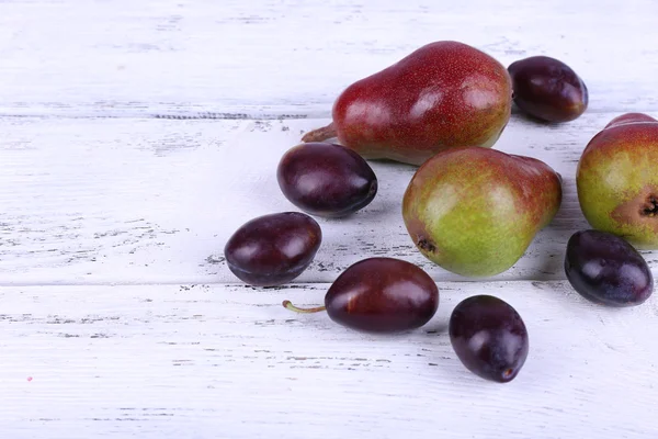 Belles poires mûres et prunes sur table en bois close-up — Photo