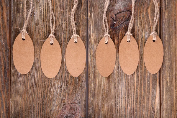 Brown tags on wooden background — Stock Photo, Image