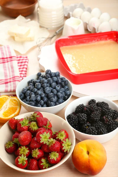 Assar torta saborosa e ingredientes para ele na mesa na cozinha — Fotografia de Stock