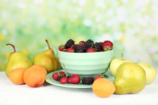 Ripe fruits and berries on table on bright background — Stock Photo, Image