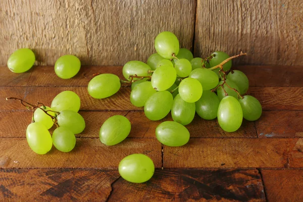 Зеленый виноград на деревянном столе на фоне — стоковое фото