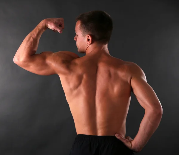 Handsome muscle young man on dark background — Stock Photo, Image