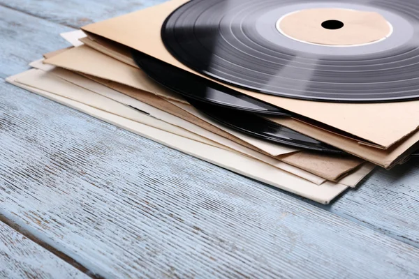 Registros de vinilo y cubiertas de papel sobre fondo de madera — Foto de Stock