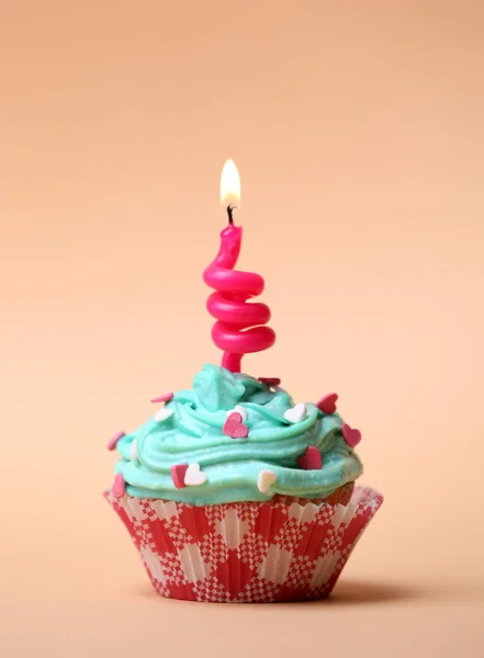 Delicioso cupcake de aniversário na mesa no fundo bege — Fotografia de Stock