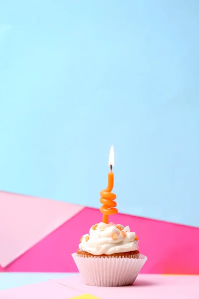 Delicioso cupcake de aniversário na mesa no fundo brilhante — Fotografia de Stock