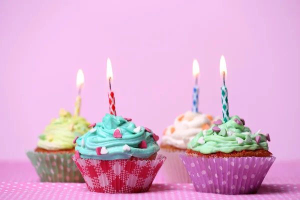 Deliciosos cupcakes de cumpleaños en la mesa sobre fondo rosa —  Fotos de Stock