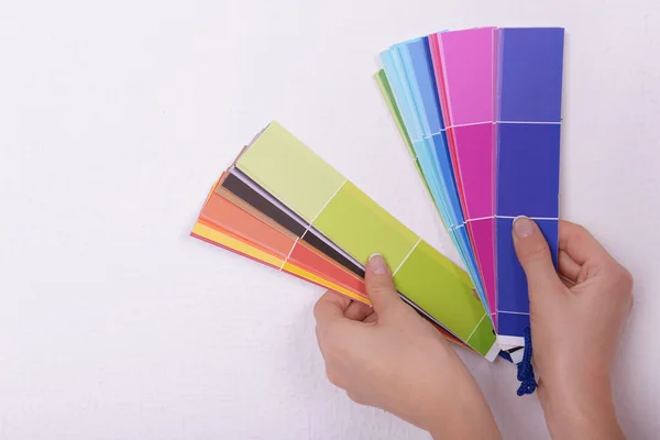 Woman choosing color for wall from swatches in room — Stock Photo, Image