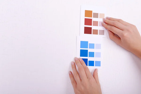 Kvinna väljer färg för vägg från kompresser i rummet — Stockfoto