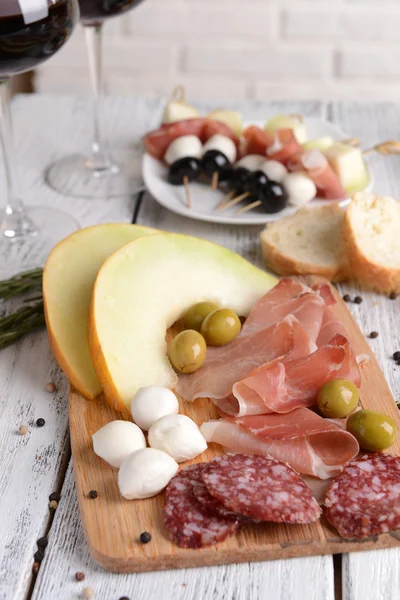 Delicious melon with prosciutto on table close-up — Stock Photo, Image