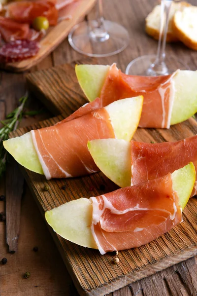 Delicious melon with prosciutto on table close-up — Stock Photo, Image