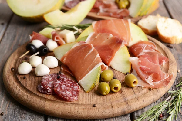 Delicious melon with prosciutto on table close-up — Stock Photo, Image