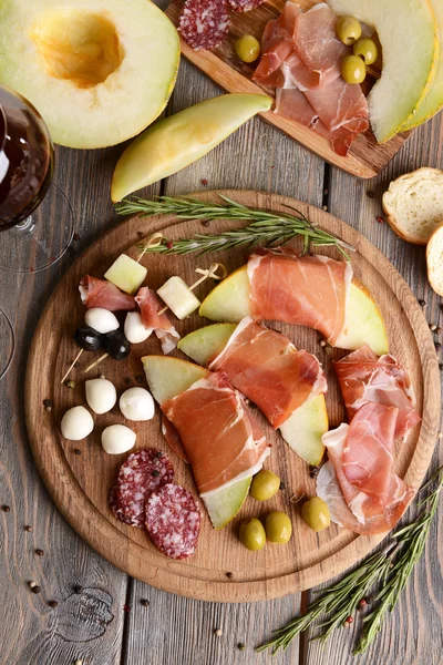 Delicious melon with prosciutto on table close-up — Stock Photo, Image