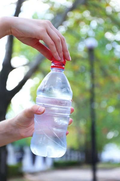 Открывающаяся вручную бутылка с водой на ярком фоне — стоковое фото