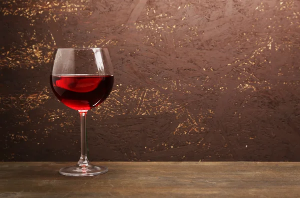 Verre de vin rouge sur table en bois sur fond mural en bois — Photo