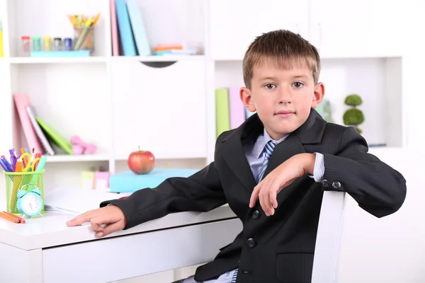 Schooljongen zitten aan tafel — Stockfoto