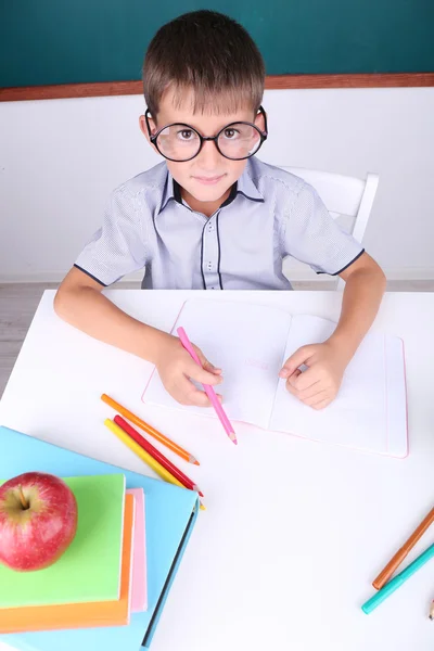 Schoolboy sitting in classroom — Stock Photo, Image