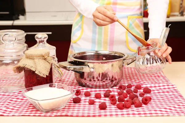 Mulher cozinhar geléia de framboesa na cozinha — Fotografia de Stock