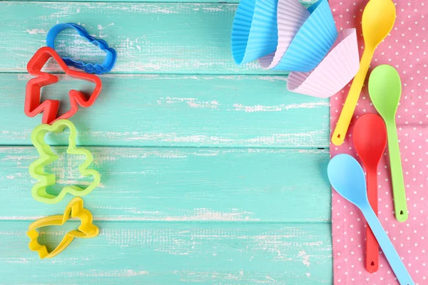 Plastic bakjes, mallen voor het knippen en lepels op een houten achtergrond kleur — Stockfoto