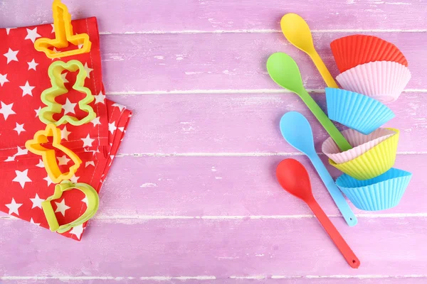 Plastic bakjes, mallen voor het knippen en lepels op een houten achtergrond kleur — Stockfoto