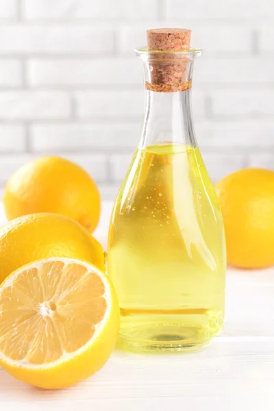 Lemon oil on table on light background — Stock Photo, Image