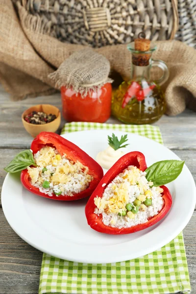 Stuffed peppers with meat and rice, on plate, on wooden background — Stock Photo, Image