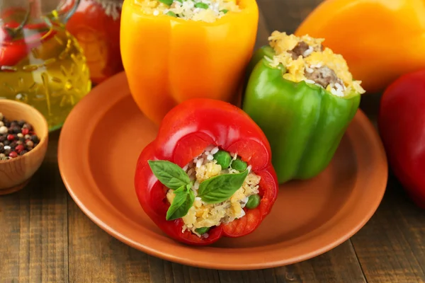 Peppers prepared for cooking with meat and rice, on plate, on wooden background — Stock Photo, Image