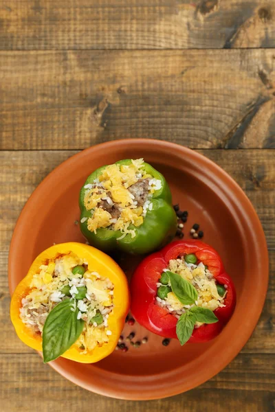Peppers prepared for cooking stuffed paprika with meat and rice, on plate, on wooden background — Stock Photo, Image