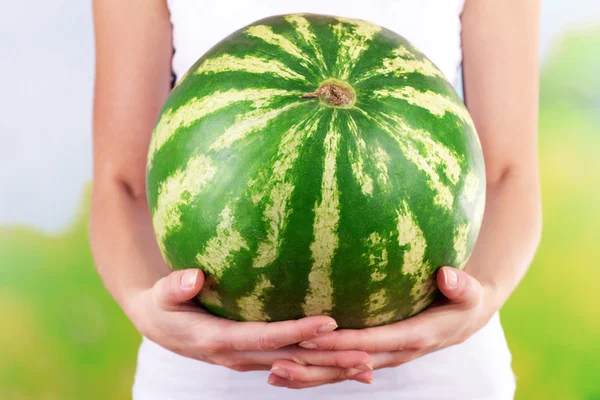 Woman holding watermelon on bright background — Stock Photo, Image