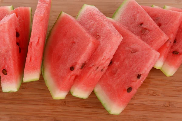 Slices of watermelon on wooden background — Stock Photo, Image