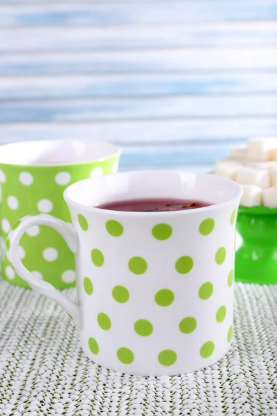 Two cups and sugar on white tablecloth on light background — Stock Photo, Image