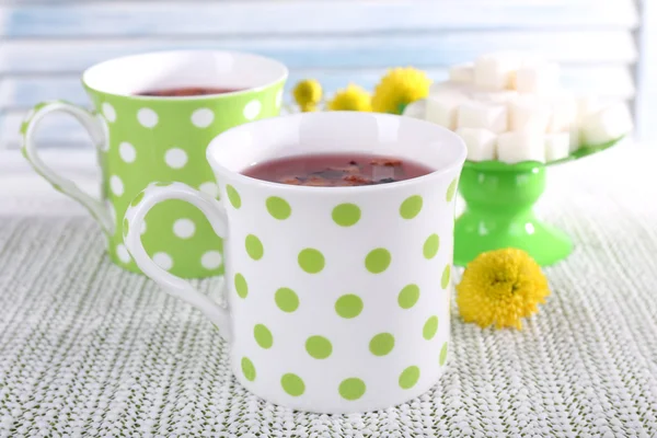 Duas xícaras e açúcar na toalha de mesa branca no fundo claro — Fotografia de Stock