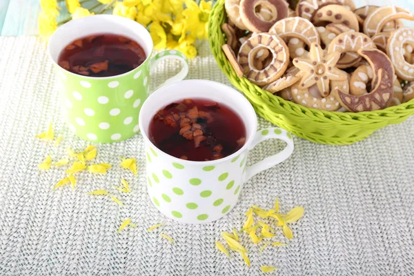 Two polka dot cups of tea with biscuits on fabric background — Stock Photo, Image